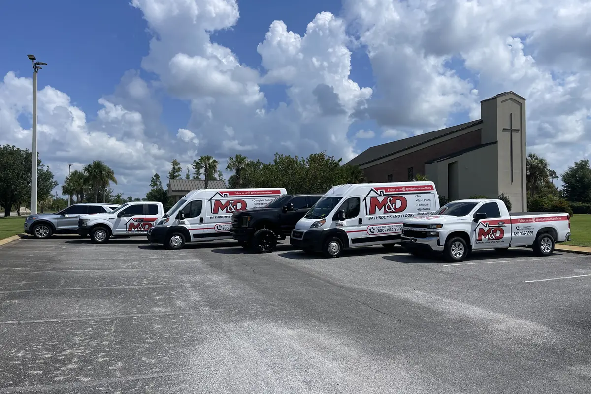 The M&D fleet of branded trucks and vans lined up in a parking lot